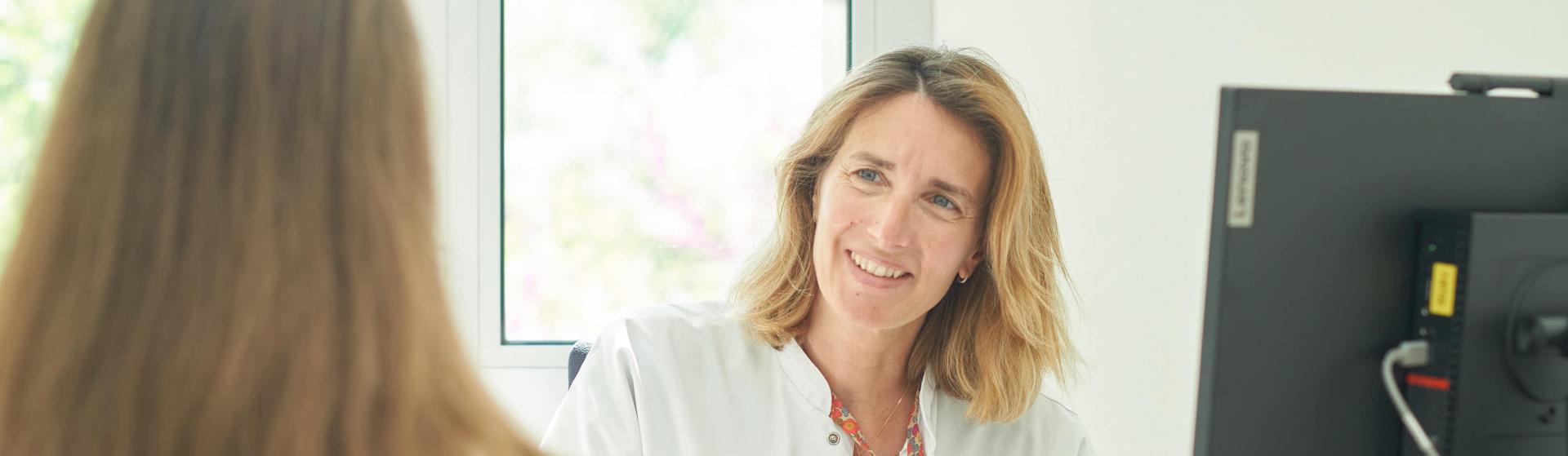 Une soignante souriante parle à un enfant