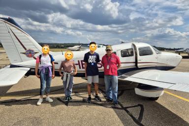 Photos d'enfants devant un avion avec le pilote de celui-ci