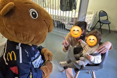 Une mascotte déguisé en castor avec une enfant et une adulte