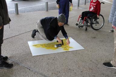 1 personne dessine à la craie la ville d'Avignon