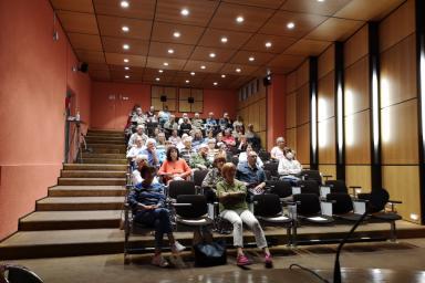 Des personnes sont assises dans un amphithéatre