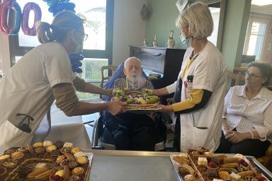 photo d'un résident qui souffle les bougies sur un gâteau d'anniversaire