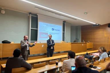 Photo de 2 conférencier à l'avant de la scène en train de parler avec un micro