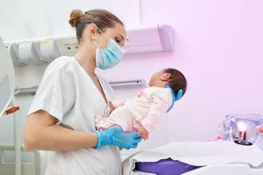 Gros plan sur une soignante tenant un nourrisson dans ses bras