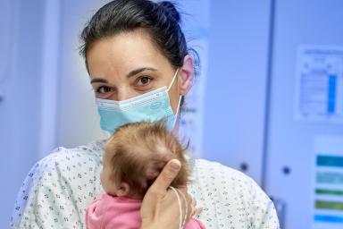 Une mère tient son bébé contre elle en souriant