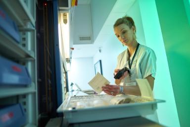 Gros plan sur une agente hospitalière de la pharmacie en train de scanner un document - Agrandir l'image, fenêtre modale