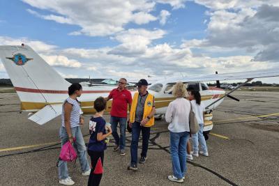 Photo de l'équipe de pédiatrie et d'enfants devant un avion - Agrandir l'image 1 sur 2, fenêtre modale