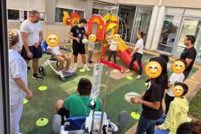 Photo d'enfants faisant des passes avec un ballon de rugby encadré par des bénévoles - Agrandir l'image 2 sur 4, fenêtre modale