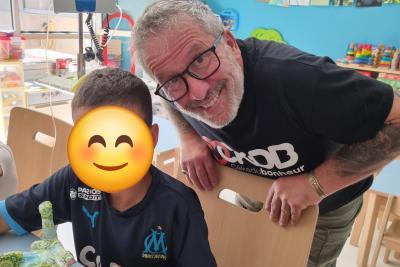 Un bénévole de l'Association Cékedubonheur aide un enfant hospitalisé à créer un éléphant avec la méthode déco patch lors d'un atelier créatif - Agrandir l'image 2 sur 3, fenêtre modale