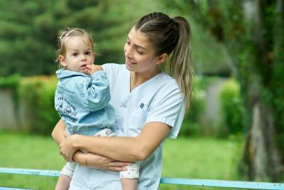 Une soignante souriante parle à un enfant - Agrandir l'image 2 sur 3, fenêtre modale
