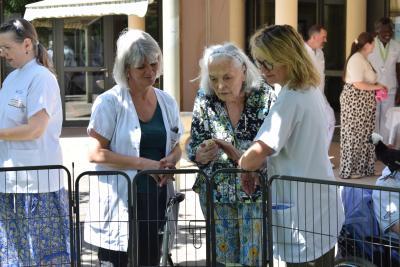 une personne porte un poussin autour de deux soignants - Agrandir l'image 3 sur 8, fenêtre modale