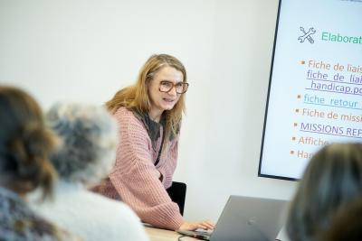 Une personne derrière un bureau et devant des personnes - Agrandir l'image 4 sur 6, fenêtre modale