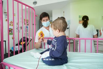 Une soignante joue avec un bébé - Agrandir l'image 1 sur 3, fenêtre modale