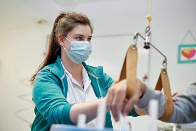 Une soignante aide un patient à la rééducation de son bras - Agrandir l'image 1 sur 6, fenêtre modale