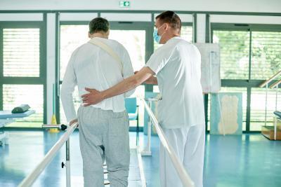 Une soignant aide un patient à marcher - Agrandir l'image 2 sur 6, fenêtre modale