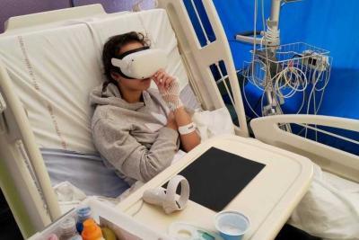Une patiente en pédiatrie avec un casque de réalité virtuelle - Agrandir l'image 1 sur 2, fenêtre modale