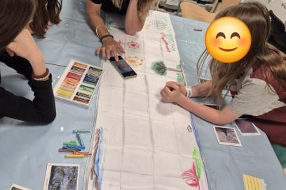 trois enfants dessinent sur une écharpe accompagné d'une médiatrice - Agrandir l'image, fenêtre modale