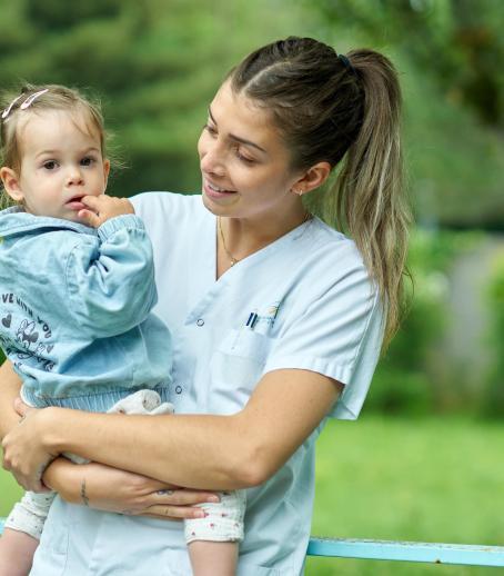 Une soignante souriante parle à un enfant