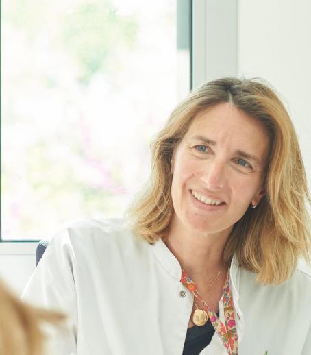 Une soignante souriante parle à un enfant