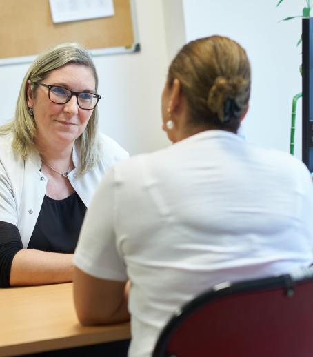 Une agente hospitalière du service social discute avec une patiente