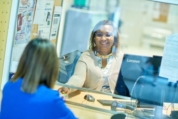 Une agente hospitalière de l'accueil rend sa carte vitale à une patiente - Agrandir l'image, fenêtre modale