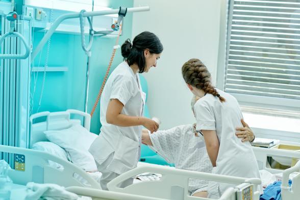 Deux soignantes s'occupent d'une patiente en chambre - Agrandir l'image, fenêtre modale