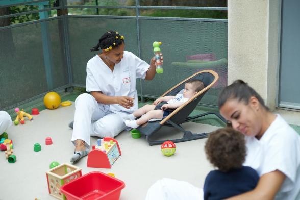 Deux soignantes jouent avec des bébés en extérieur - Agrandir l'image, fenêtre modale