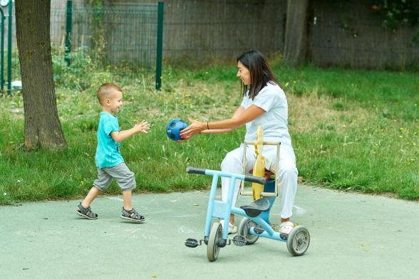 Gros plan sur une soignante qui joue au ballon avec un petit garçon - Agrandir l'image, fenêtre modale