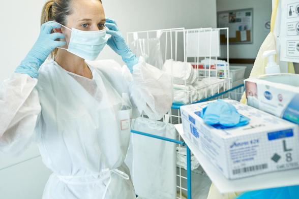 Une soignante met son masque - Agrandir l'image, fenêtre modale