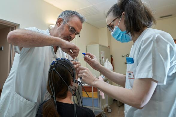 Des soignants posent des électrodes d'Electroencéphalographie sur la tête d'un patient - Agrandir l'image, fenêtre modale