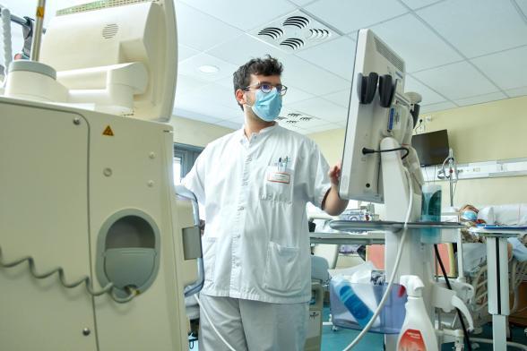 Un soignant consulte une machine - Agrandir l'image, fenêtre modale