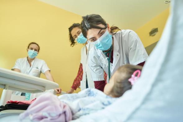 Des soignantes s'occupent d'une enfant en chambre - Agrandir l'image, fenêtre modale