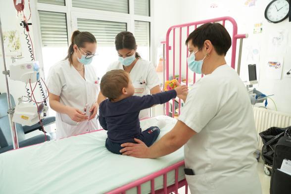Des soignantes s'occupent d'un bébé - Agrandir l'image, fenêtre modale