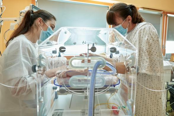 Deux soignantes s'occupent d'un nourrisson en couveuse - Agrandir l'image, fenêtre modale
