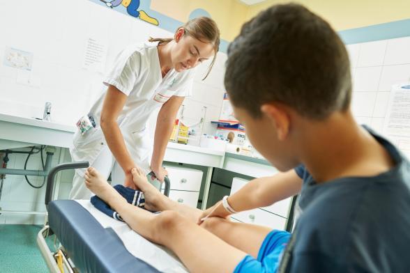 Une soignante s'occupe d'un jeune patient - Agrandir l'image, fenêtre modale