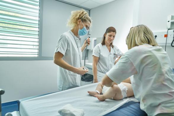 Des soignantes s'occupent d'un bébé - Agrandir l'image, fenêtre modale