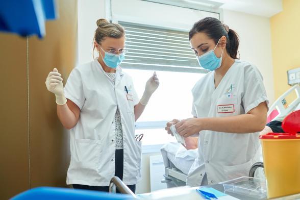 Deux soignantes ouvrent du matériel médical - Agrandir l'image, fenêtre modale