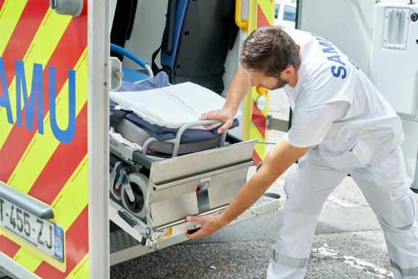 Un soignant pousse un brancard dans un camion - Agrandir l'image, fenêtre modale