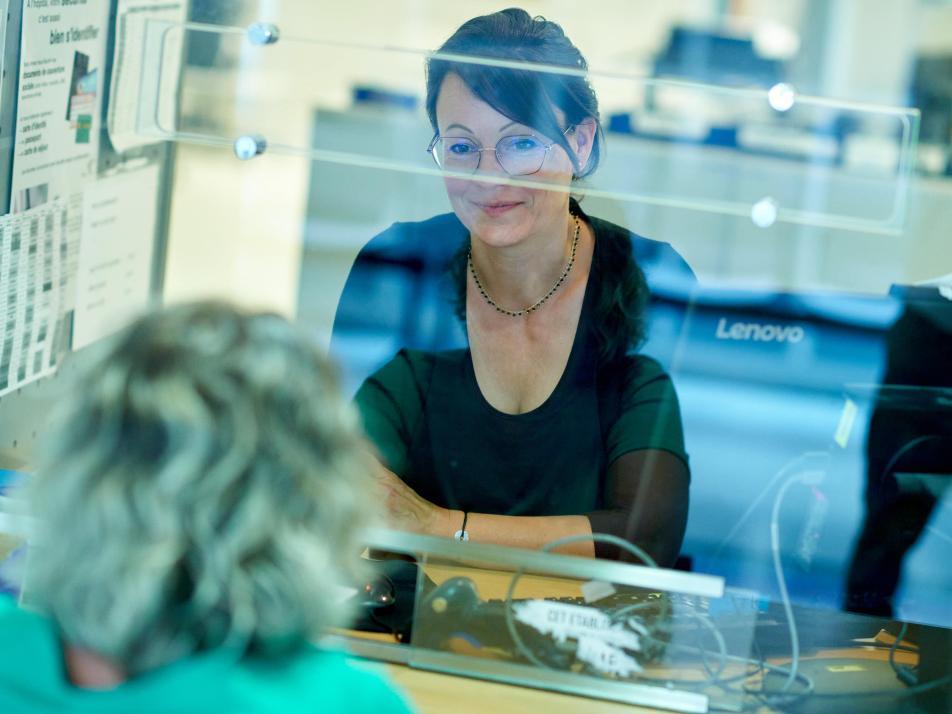 Une agente hospitalière de l'accueil souriant à une patiente